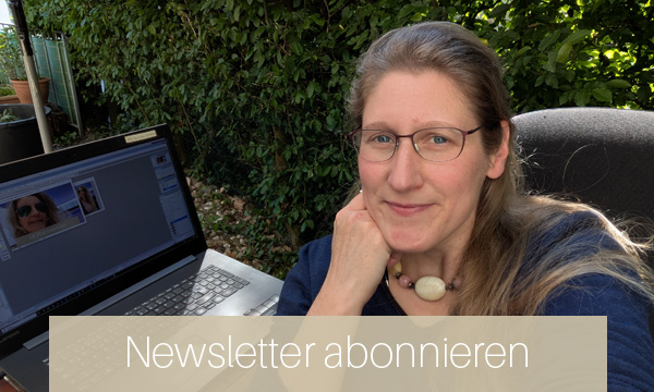 Dorothee sitzt am Laptop auf der Terrasse vor einer Hecke und macht Pause von der Newsletter-Erstellung