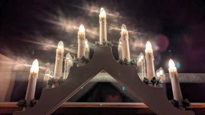 Eine Lichterpyramide leuchtet im Fenster in der Adventszeit